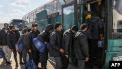 FILE - Illegal migrants from Egypt board a bus during a deportation operation in the Libyan capital Tripoli on January 31, 2024.