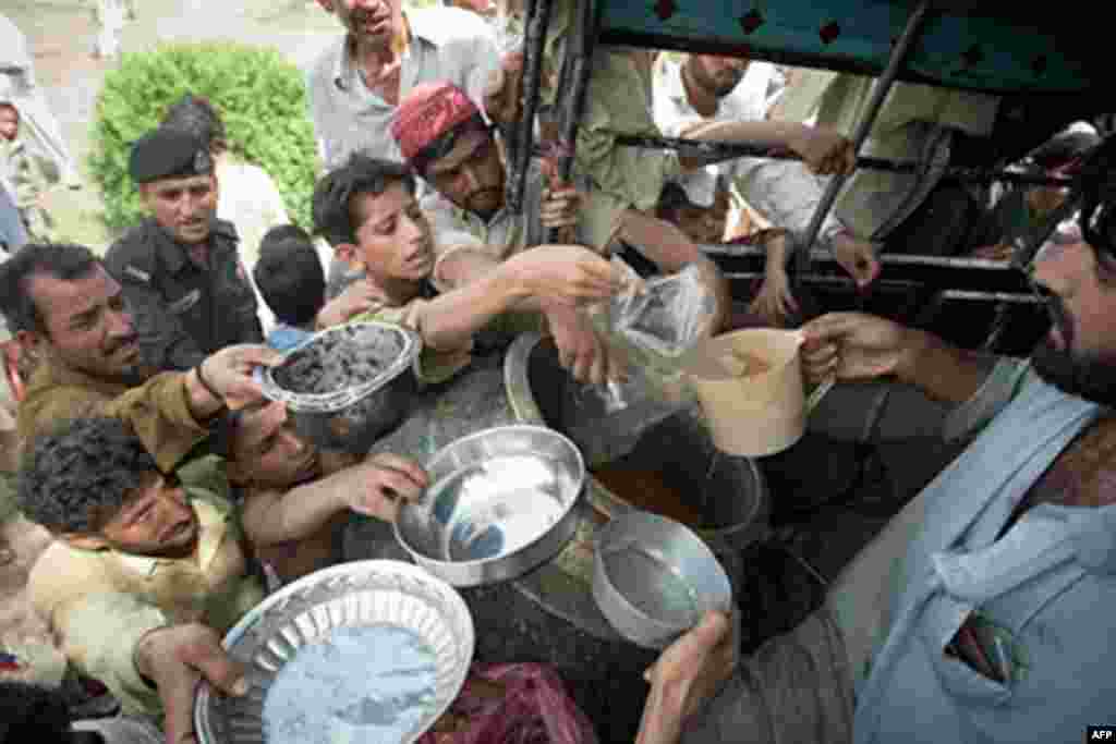 Pakistani men and boys gather to receive food at a camp for the displaced set up inside a college on the outskirts of Nowshera on August 2, 2010. Fears were growing Monday for up to 2.5 million people affected by Pakistan's worst floods in 80 years amid o