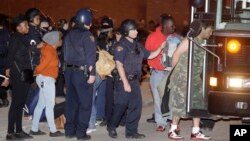 Protesters are escorted to a bus for transport after getting arrested after protesting the acquittal of Cleveland police officer Michael Brelo, May 23, 2015, in Cleveland, Ohio.