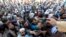 Afghan men wait to collect tokens needed to apply for the Pakistan visa, in Jalalabad, Afghanistan, Oct. 21, 2020. 
