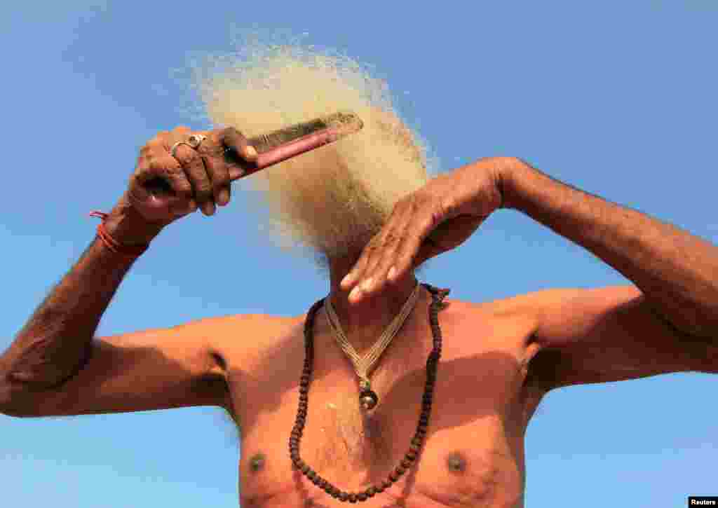 A Sadhu or Hindu holy man combs his beard after taking a dip in the waters of Shipra River during Simhastha Kumbh Mela in Ujjain, India.