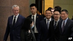 中国国务院副总理何立峰(右一)和法国经济部长勒梅尔(左一).