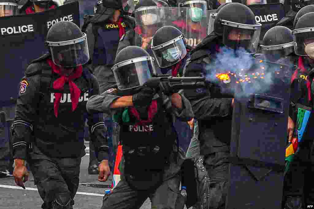 A riot policeman fires rubber bullets at protesters in a demonstration calling for the resignation of Thailand&#39;s Prime Minister Prayut Chan-O-Cha over the government&#39;s handling of the Covid-19 crisis in Bangkok.