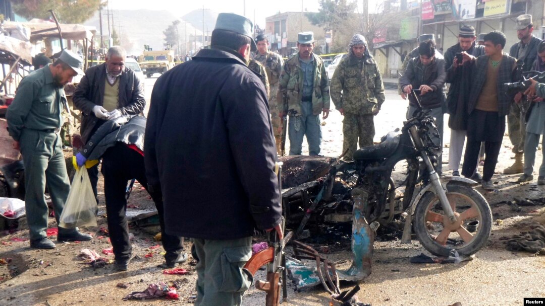 An Afghan police officer stands at the site of a suicide blast in Faryab, northern Afghanistan, March 18, 2014.