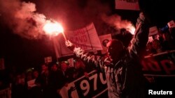 A demonstrator holds a flare during civic protest in Podgorica, Montenegro, March 2, 2019.