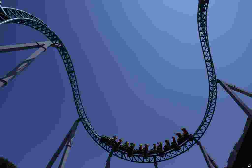 Visitors enjoy a ride on a roller coaster at Cinecitta World amusement park in the outskirts of Rome, Italy, on the day of its reopening.