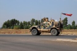 A U.S. military vehicle, part of a convoy, arrives near Dahuk, Iraqi, Oct. 21, 2019.