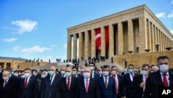  گروهی از اعضای پارلمان ترکیه در مقابل ساختمان آن با ماسک بر صورت. 