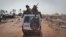 FILE - South Sudanese government forces ride on a vehicle through a still-smoldering town in Unity State, South Sudan, Jan 12, 2014. The leader of the National Salvation Front said the government is to blame for initiating current fighting in Yei River State.