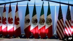 National flags representing Canada, Mexico, and the U.S. are lit by stage lights at the North American Free Trade Agreement, NAFTA, renegotiations, in Mexico City, Sept. 5, 2017. 