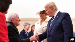 Presiden Donald Trump bersalaman dengan veteran Perang Dunia II dalam peringatan 75 tahun D-Day di Portsmouth, Inggris, 5 Juni 2019.