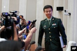 China's Defense Ministry spokesman Wu Qian leaves as journalists are asking question on Hong Kong's recent protests after a press conference at the State Council Information Office in Beijing, July 24, 2019.