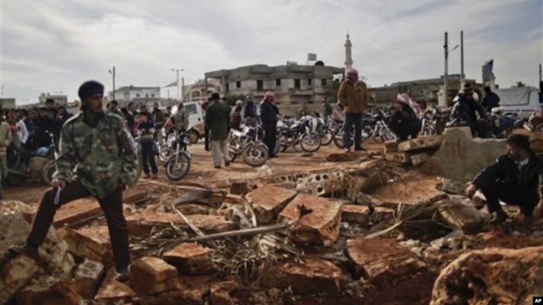 Warga Suriah menunggu di luar sebuah toko untuk membeli roti di Maaret Misreen, dekat Idlib, Suriah. Kota ini terlihat hancur dan sangat bergantung pada sumbangan para donatur lokal (Foto: dok). PBB menilai konflik di Suriah yang sudah berlangsung hampir dua tahun ini semakin bernuansa konflik antar golongan. 
