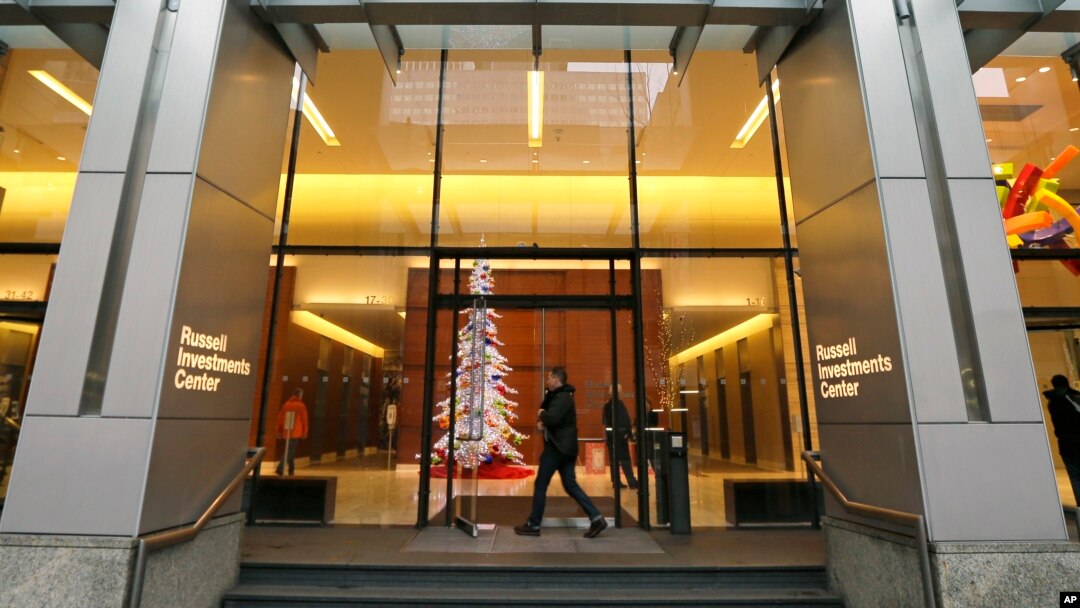 People enter the Russell Investments Center building Monday, Dec. 7, 2015, in Seattle. Over 100 people have gotten sick in a norovirus outbreak at the office building, health officials reported Monday.