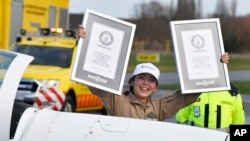 Belgium-British teenage pilot Zara Rutherford holds up her certificates after landing her Shark ultralight plane at the Kortrijk airport in Kortrijk, Belgium, Jan. 20, 2022. 