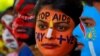 FILE - Students with their faces painted with messages pose during an HIV/AIDS awareness campaign to mark the International AIDS Candlelight Memorial, in Chandigarh, India, May 20, 2018. 