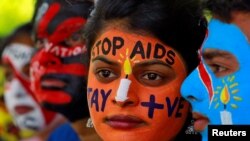 Siswa di India melukis wajahnya ketika berpawai untuk meningkatkan kesadaran tentang HIV/AIDS di Chandigarh, India, 20 Mei 2018. 