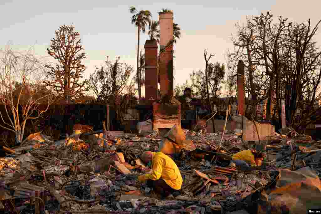 Pedram Salimpour and Stacy Weiss look through the remains of their home, which was destroyed by the Palisades Fire, in the Pacific Palisades neighborhood in Los Angeles, California, Jan. 11, 2025. 