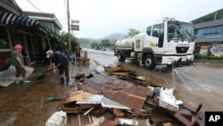 Penduduk di Cheorwon, Korea Selatan, membersihkan lumpur yang terbawa banjir akibat hujan lebat yang melanda kawasan tersebut, 6 Agustus 2020. 