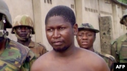 Le chef de la secte islamique Boko Haram Mohammed Yusuf, 39 ans, entouré de soldats, peu après sa capture par les troupes nigérianes, à la caserne de Giwa à Maiduguri, au nord-est du Nigeria, 5 août 2009.