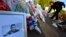A picture of victim Drummer Lee Rigby, of the British Army's 2nd Battalion The Royal Regiment of Fusiliers is displayed with flowers left by mourners outside an army barracks near the scene of his killing in Woolwich, southeast London May 23, 2013.