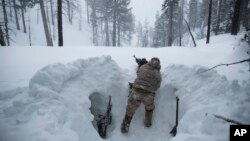 A U.S. Marine covers a machine gun in a trench while preparing for advanced cold-weather training at the Marine Corps Mountain Warfare Training Center on Saturday, Feb. 9, 2019, in Bridgeport, Calif. (AP Photo/Jae C. Hong)