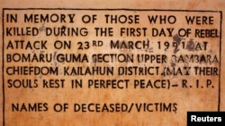 FILE - A sign commemorating the start of the civil war is displayed April 22, 2012, at a memorial site where the conflict began, in the village of Bomaru, eastern Sierra Leone. Sierra Leone's 11-year conflict from 1991-2002 left over 50,000 dead and became a byword for gratuitous violence, especially the amputation of limbs.