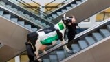Men carry a fake cow while riding an escalator during preparations for the Green Week international food, agriculture and horticulture fair in Berlin, Germany.