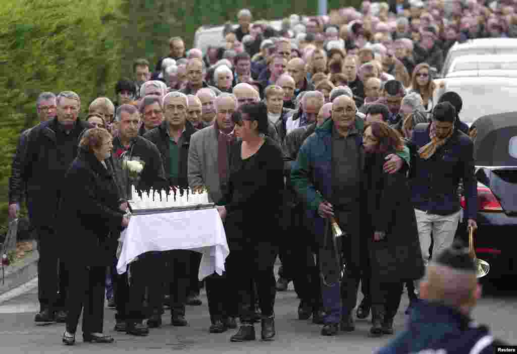 People walk during a demonstration to pay homage two days after a fatal bus crash in Puisseguin, in Petit-Palais-et-Cornemps, southwestern France. At least 41 people on the coach taking pensioners on a day excursion were killed when it collided head-on with the truck in France's Bordeaux wine-growing region and burst into flames.