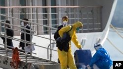 Un tripulante del crucero australiano Mortimer es desinfectado al bajar de la embarcación en Montevideo, Uruguay, el 12 de mayo de 2020.