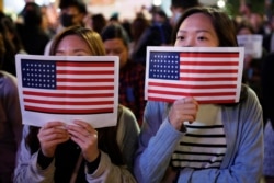 Protester holds U.S. flags during a demonstration in Hong Kong, Nov. 28, 2019.