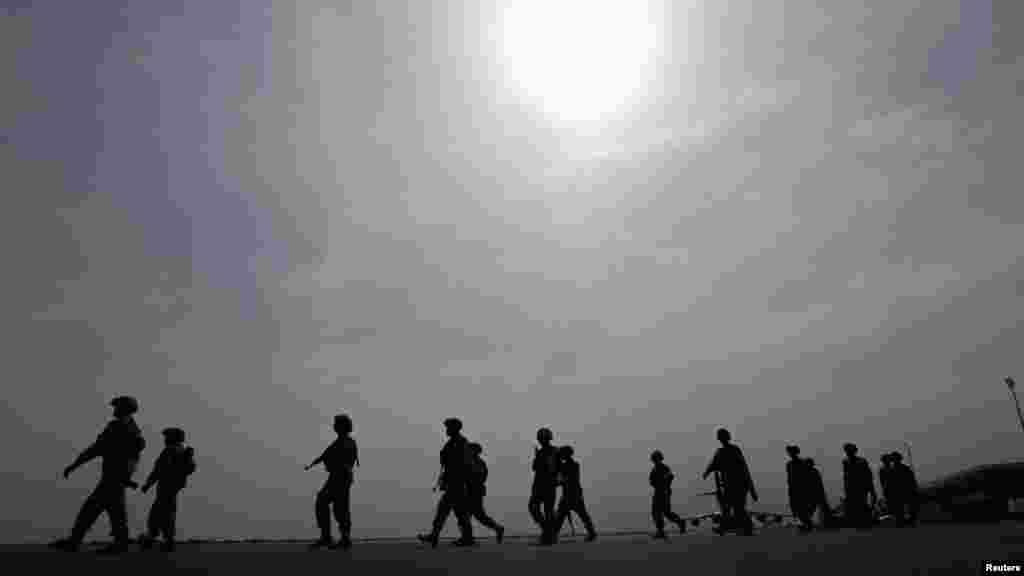 Nigerian soldiers walk on the tarmac of the Bamako airport.