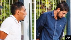 In this combination photo, two un-named alleged members of a terror cell accused of killing 15 people in attacks in Barcelona leave a Civil Guard base on the outskirts of Madrid before appearing in court in Madrid, Spain, Aug. 22, 2017.