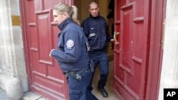 French police officers exit the residence of Kim Kardashian West in Paris Monday, Oct. 3, 2016. 