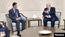 In a photo released by Syria's national news agency, SANA, Syria's President Bashar al-Assad, left, talks to Jean-Pierre Vial, leader of a delegation of French lawmakers, in Damascus, Feb. 25, 2015.