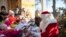 A man dressed as Santa Claus is welcomed by children during the opening of the most famous German Christmas mail office in the small village of Himmelpfort (Heaven's Door) north of Berlin, Germany, Nov. 14, 2019.