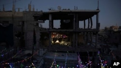 Palestinos colocan decoraciones cerca de sus viviendas destrozadas por la guerra, antes del inicio del mes sagrado del islam, el Ramadán, en Jan Yunis, en el sur de la Franja de Gaza, el 28 de febrero de 2025. (AP Foto/Jehad Alshrafi).