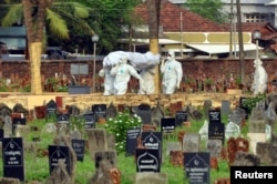 Dokter dan kerabat yang mengenakan APD membawa jenazah seorang korban yang terjangkit virus Nipah yang merusak otak, di Kozhikode, di India selatan, 24 Mei 2018. (Foto: Reuters)