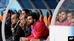 Pesepak bola Mesir, Mohamed Salah (tengah), menyaksikan timnya bertanding dalam laga penyisihan Grup A antara Mesir dan Uruguay di turnamen Piala Dunia 2018, di Yekaterinburg Arena, Yekaterinburg, Rusia, 15 Juni 2018.