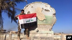 Irački vojnik drži zastavu na vladinom kompleksu u centru Ramadija, 28. decembar 2015.