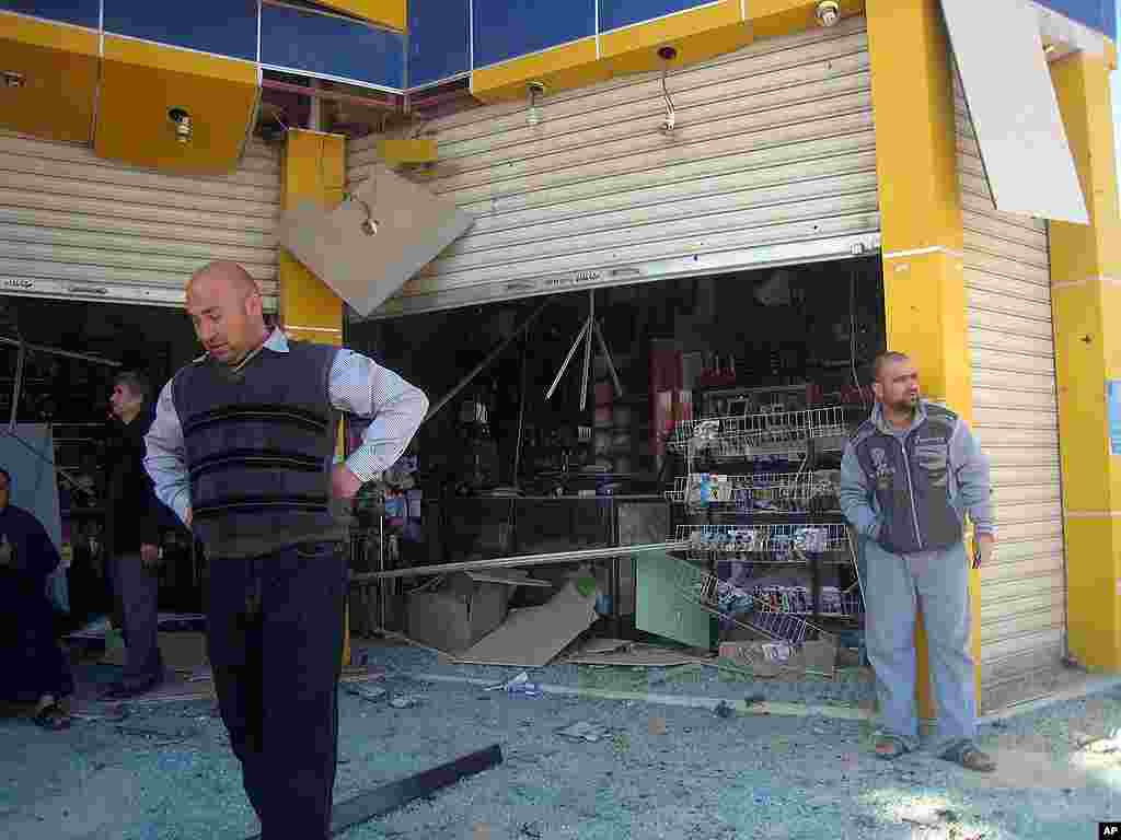 People inspect the scene of a car bomb attack in Kirkuk. (AP)