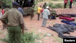 Des militaires kenyans et volontaires de la Croix-Rouge transportent des corps dans une carrière dans le village de Korome, à proximité de Madera le 2 décembre 2014.