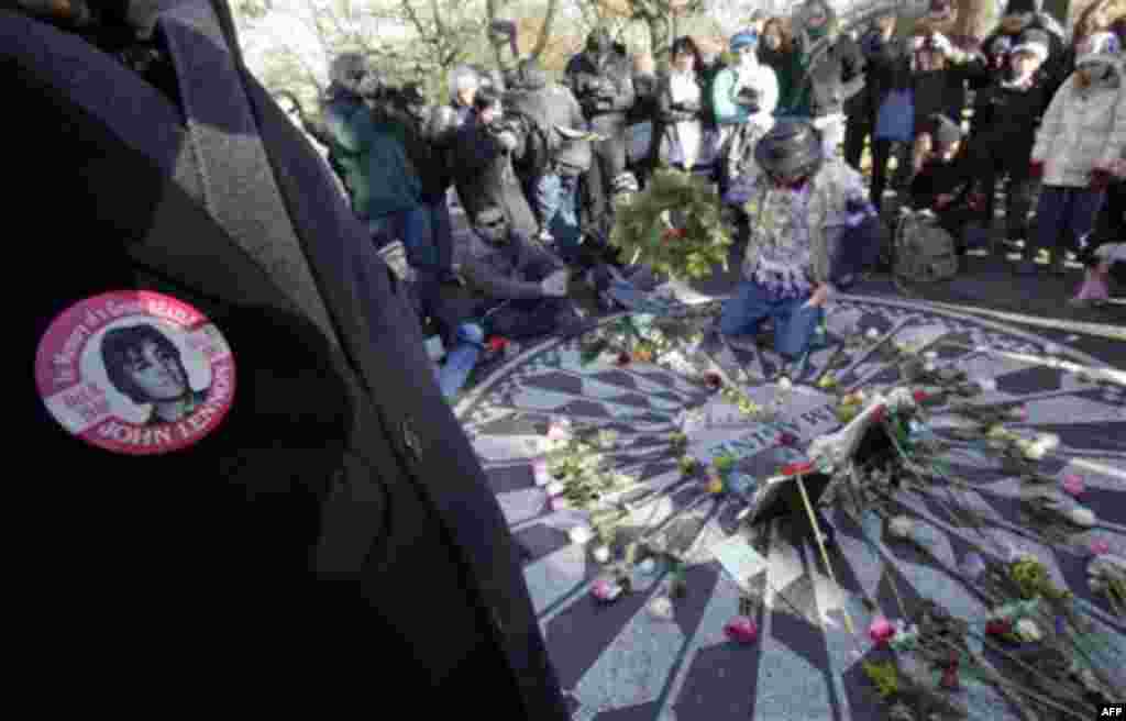 People surround the Imagine mosaic as a wreath is placed, in the Strawberry Fields section of New York's Central Park, Wednesday, Dec. 8, 2010, the 30th anniversary of the death of John Lennon. (AP Photo/Richard Drew)