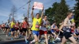Runners in the first wave of 9,000 cross the start line of the 118th Boston Marathon, in Hopkinton, Mass., April 21, 2014.