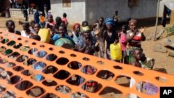 FILE - People celebrate as they are released from Ebola quarantine in the village of Massessehbeh on the outskirts of Freetown, Sierra Leone, Aug. 14, 2015.