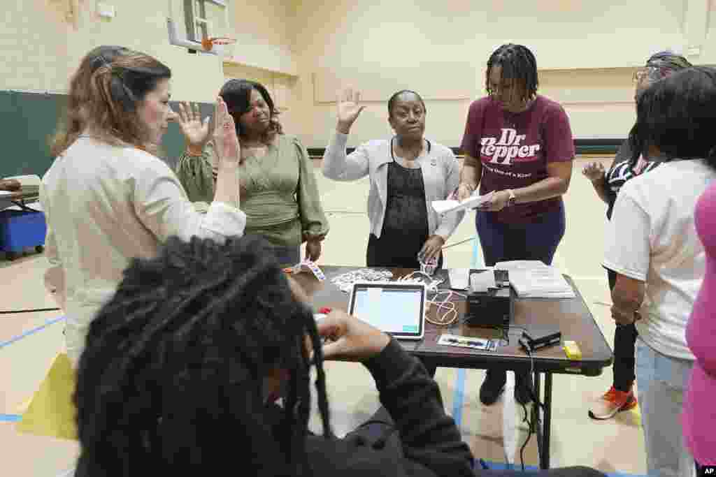 North Jackson, Mississippi, precinct workers recite their pledge of office prior to opening the site for early morning voters, Nov. 5, 2024.