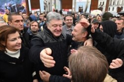 Demonstrators greet former Ukrainian President Petro Poroshenko (C) in central Kyiv Oct. 6, 2019, during a protest against broader autonomy for separatist territories, part of a plan to end a war with Russian-backed fighters.