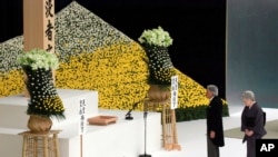 Japan's Emperor Akihito, accompanied by Empress Michiko, walks to deliver his remarks in front of the main altar during a memorial service for the war dead at Nippon Budokan martial arts hall Wednesday, Aug. 15, 2018, in Tokyo.