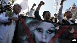 Muslim men shout slogans during a rally against US pop singer Lady Gaga's concert that is scheduled to be held on June 3, outside the US Embassy in Jakarta, Indonesia, May 25, 2012. 