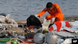 A member of Indonesian Search and Rescue Agency (BASARNAS) inspects debris believed to be from Lion Air passenger jet that crashed off Java Island at Tanjung Priok Port in Jakarta, Indonesia, Oct. 29, 2018. 